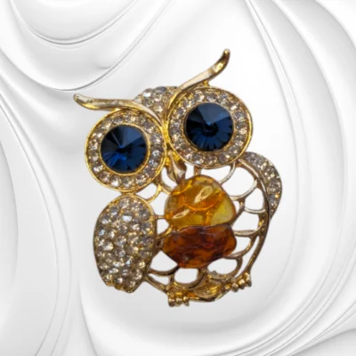 Broszka ze stali chirurgicznej w kształcie sowy z bursztynem bałtyckim i kryształkami