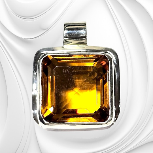 Srebrna zawieszka z fasetowanym cytrynem o ciepłym, złocistym kolorze.