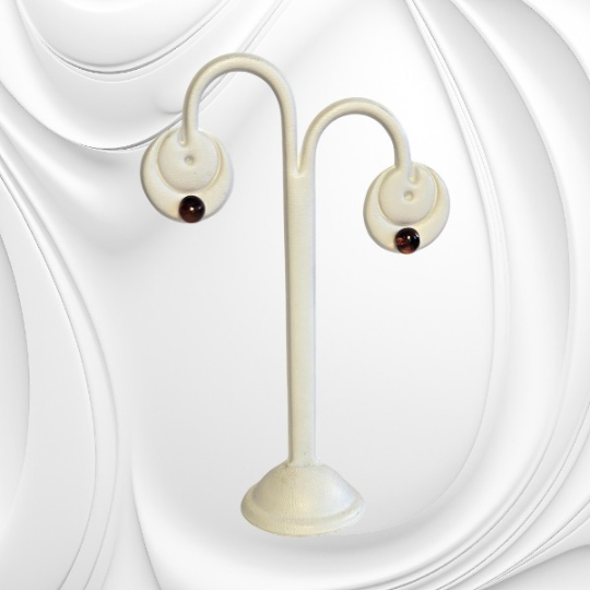 Srebrne kolczyki sztyfty z kulką bursztynu w odcieniu koniaku prezentujące elegancką i minimalistyczną formę.