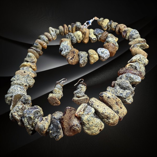 Komplet z surowych bryłek bursztynu bałtyckiego – naszyjnik, bransoletka i kolczyki ze srebrnymi zapięciami.