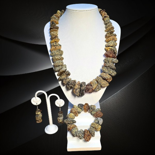 Komplet z surowych bryłek bursztynu bałtyckiego – naszyjnik, bransoletka i kolczyki ze srebrnymi zapięciami.