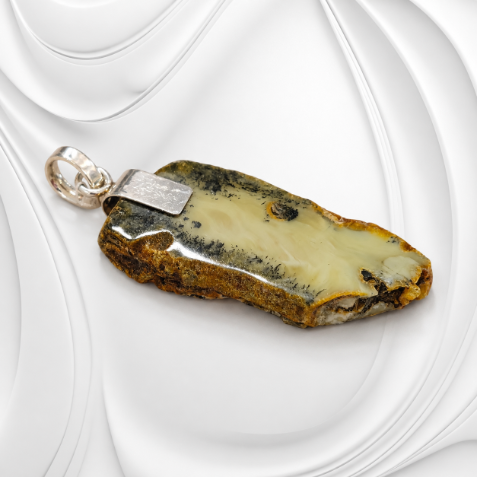 Duża zawieszka z naturalnego bursztynu bałtyckiego oprawionego w srebro próby 925 o wymiarach 68 × 33 mm.