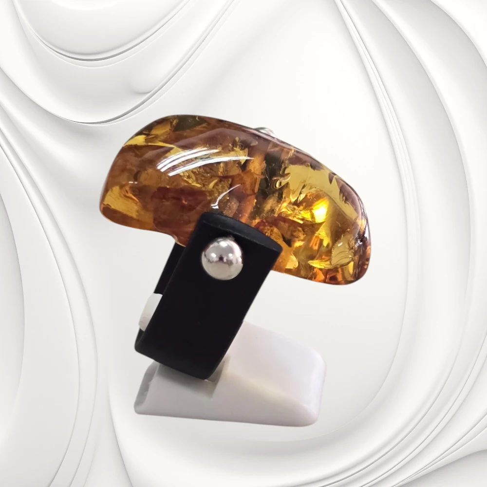 Designerski pierścionek z bursztynem 33 × 17 mm na czarnej kauczukowej obrączce. Efektowna złocisto-miodowa barwa i możliwość zmniejszenia rozmiaru.